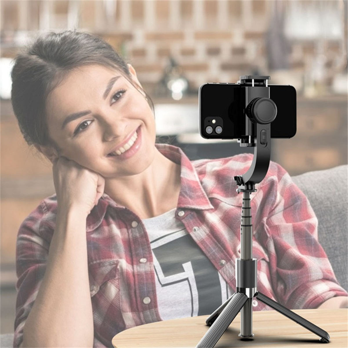 Frau macht ein Foto mit einem Smartphone, das an einem Stativ befestigt ist.