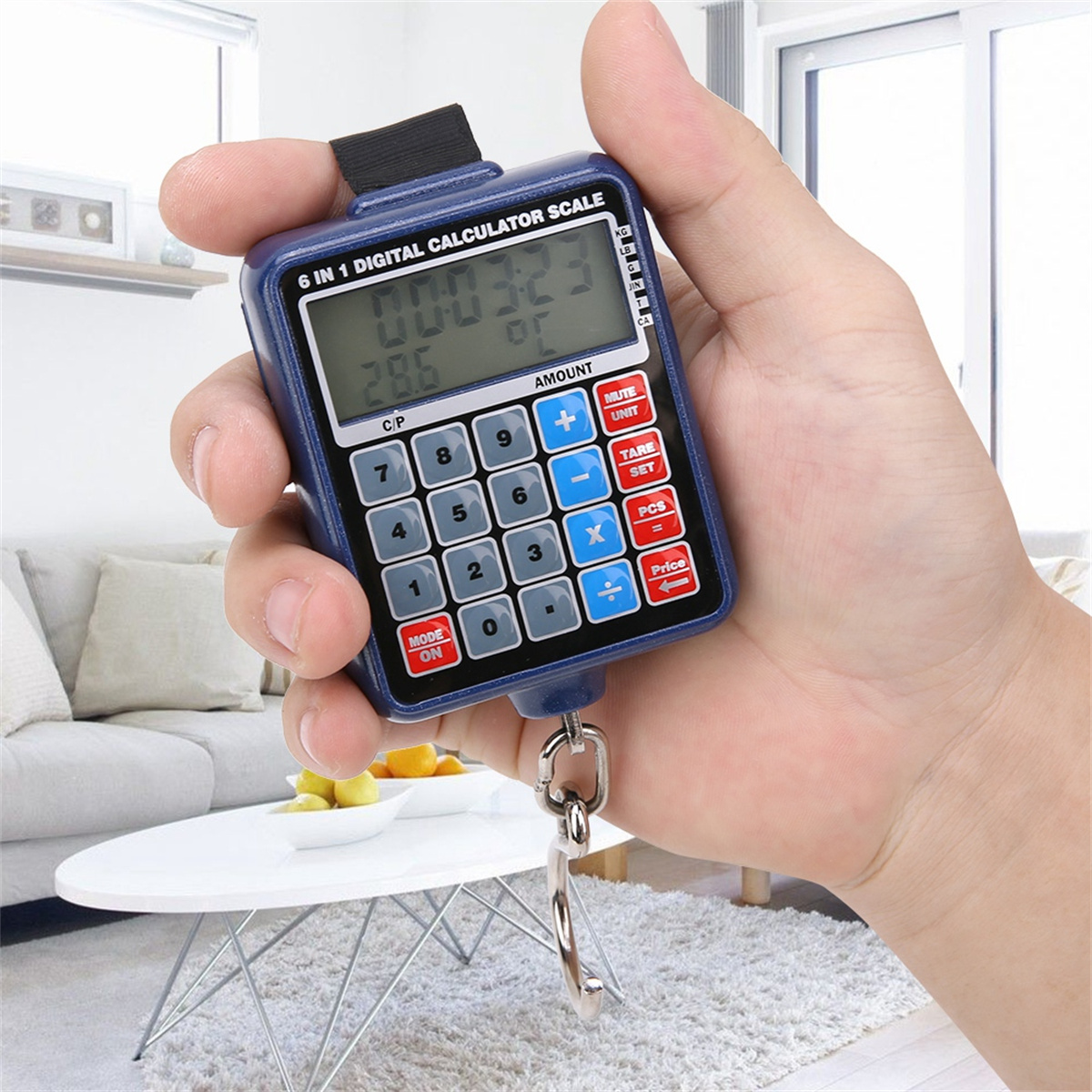 Eine Hand hält eine blaue digitale Taschenwaage. Sie zeigt Zahlen an. Im Hintergrund steht ein weißer Tisch.