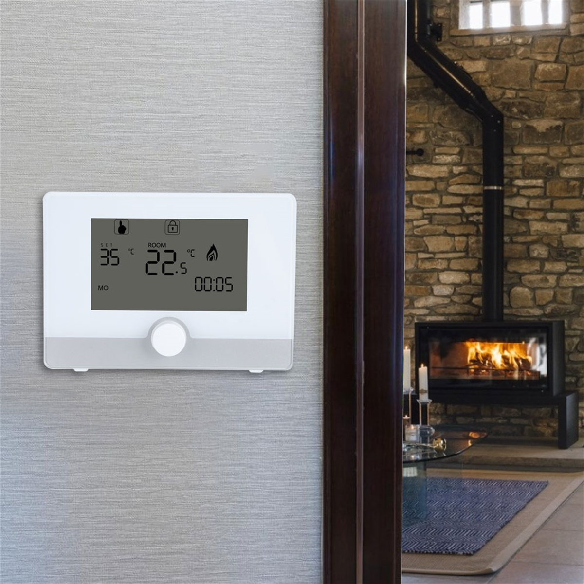 Digitales Thermostat an einer grauen Wand. Kamin im Hintergrund.