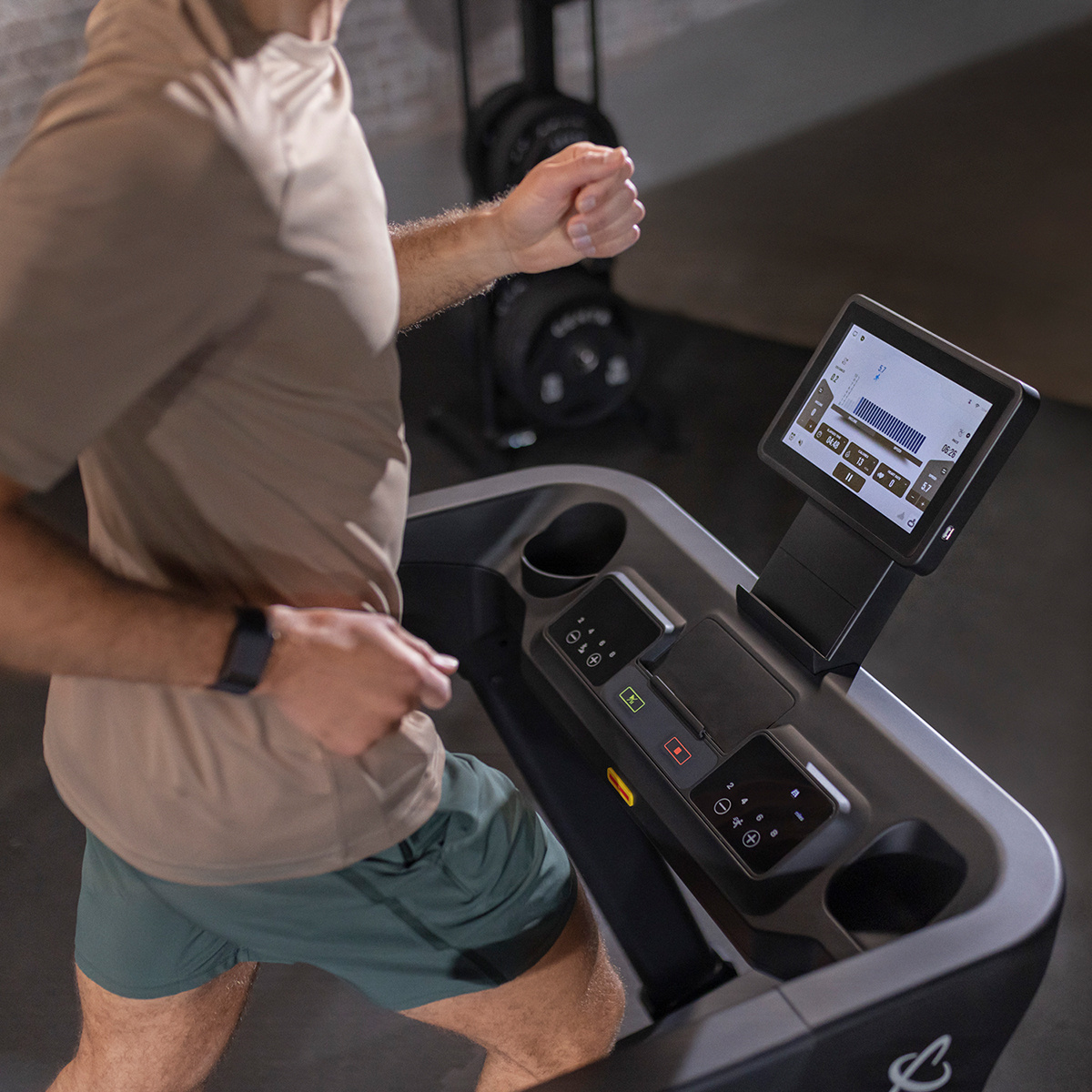 Man running on a treadmill with a digital display, in a home gym setting.