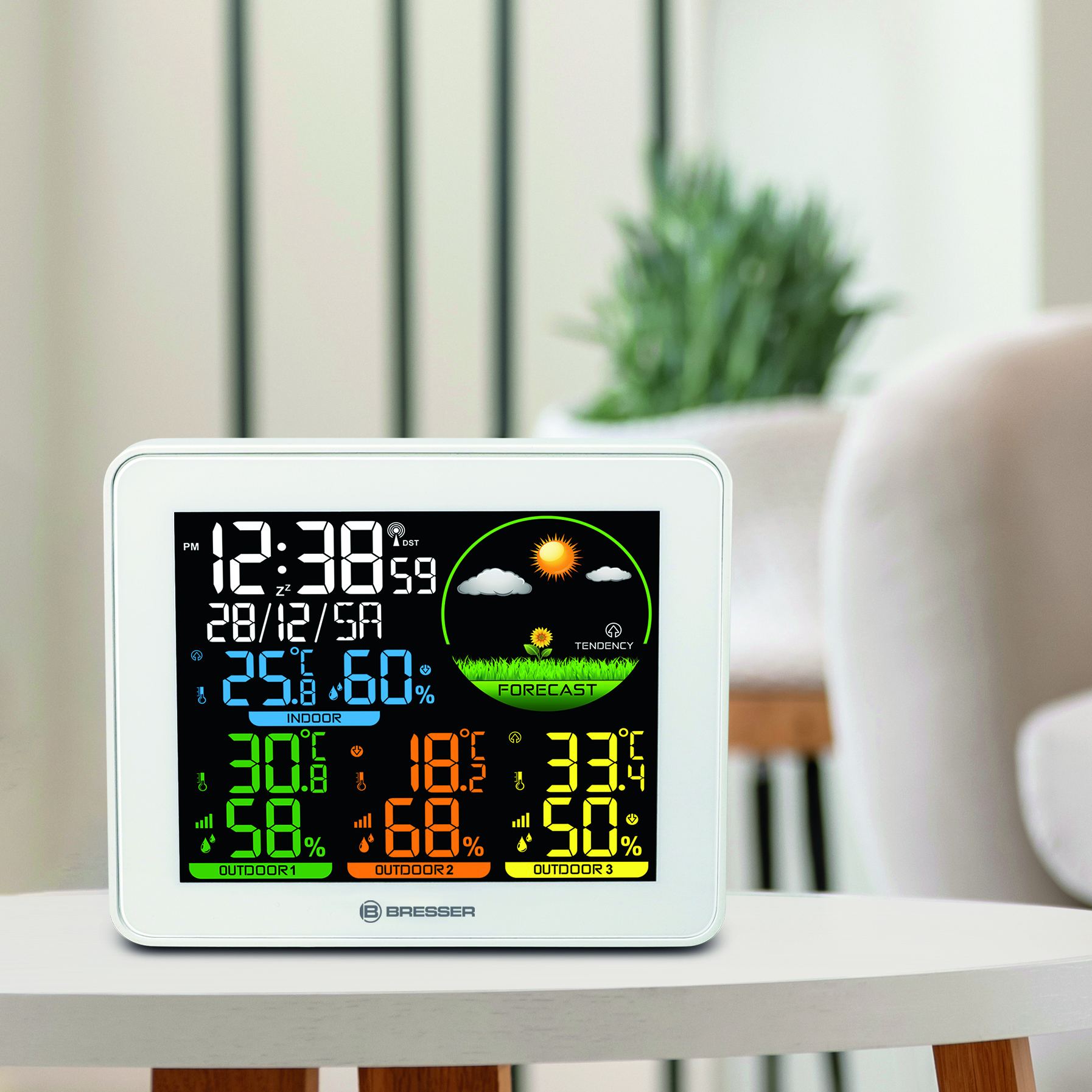 Estación meteorológica digital blanca que muestra la hora, la fecha y los datos meteorológicos.