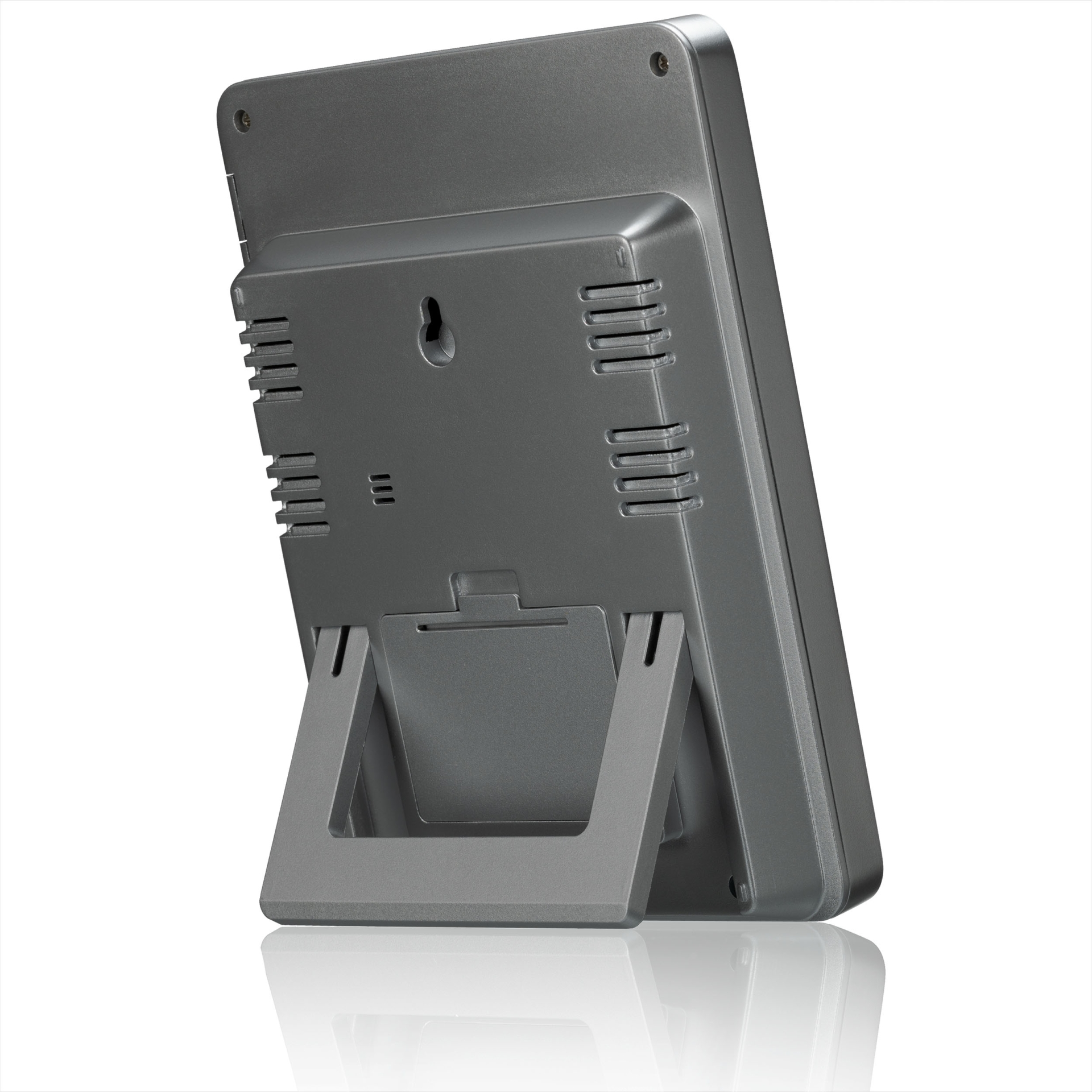 Dispositivo digital gris con soporte. Tiene un orificio para montaje en pared y ventilaciones.