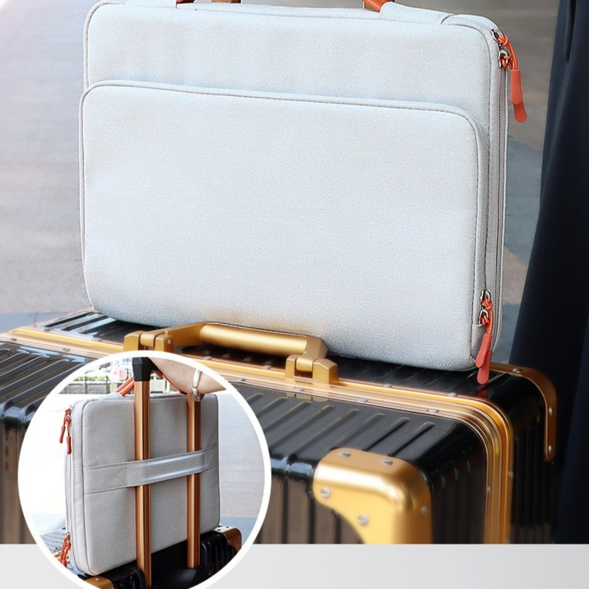 Hellgraue Laptoptasche auf einem Koffer. Zusätzliche Tasche mit Gepäckriemendetails sichtbar.