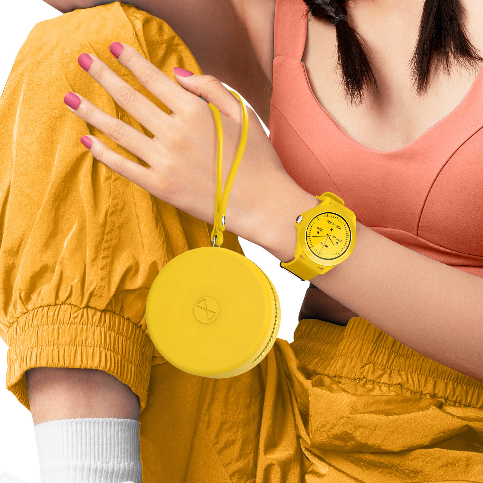 Osoba nosząca żółty zegarek i trzymająca żółte okrągłe urządzenie. Ma na sobie żółty strój.