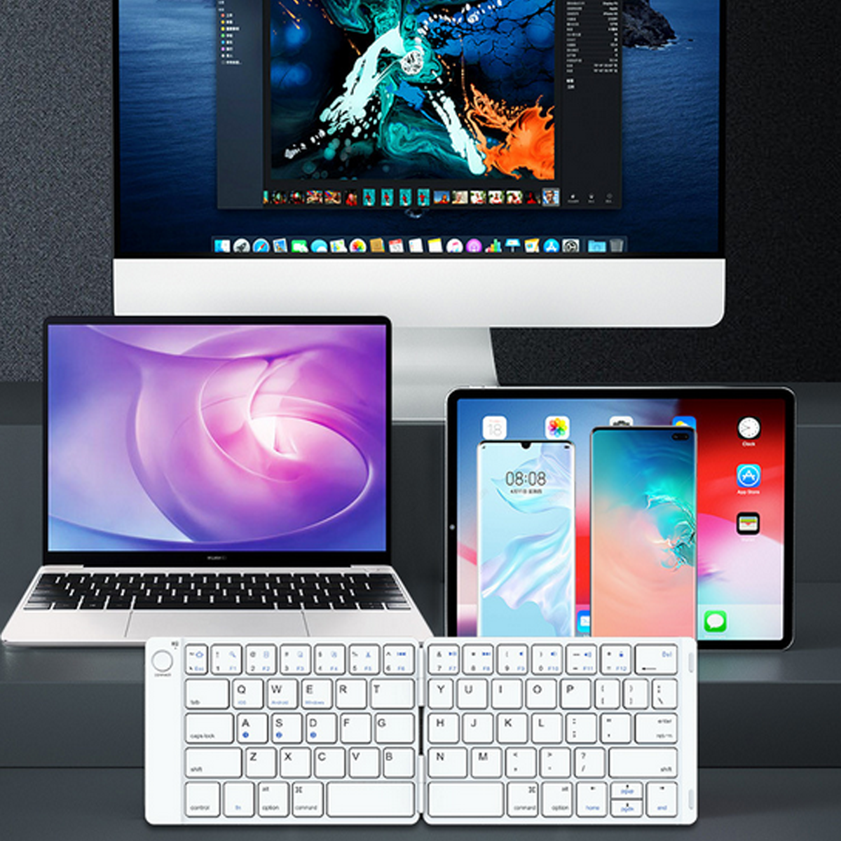 Laptop, Tastatur, Tablet und Telefon auf einer Oberfläche.