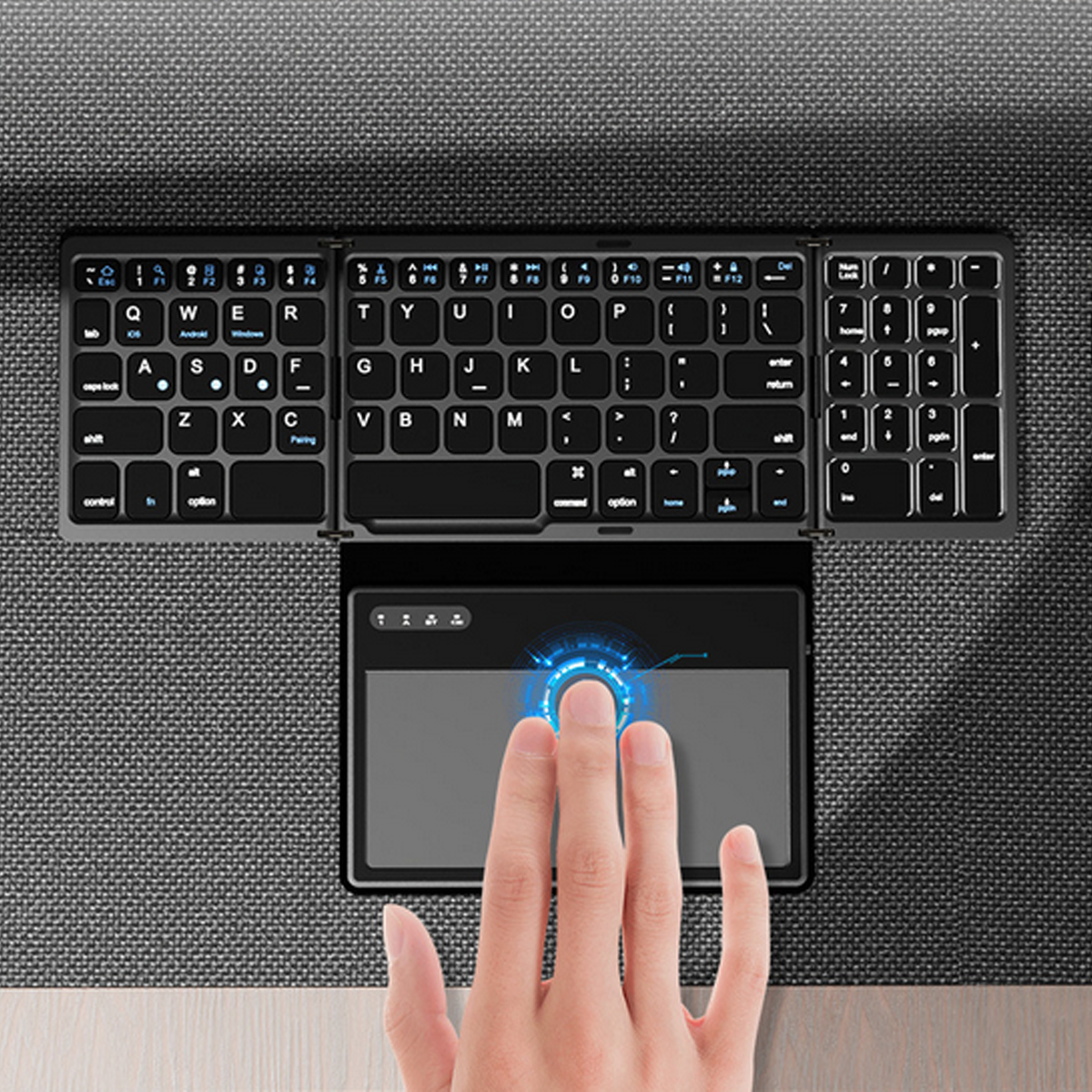 Eine faltbare Tastatur mit Touchpad und eine Hand, die das Touchpad berührt.