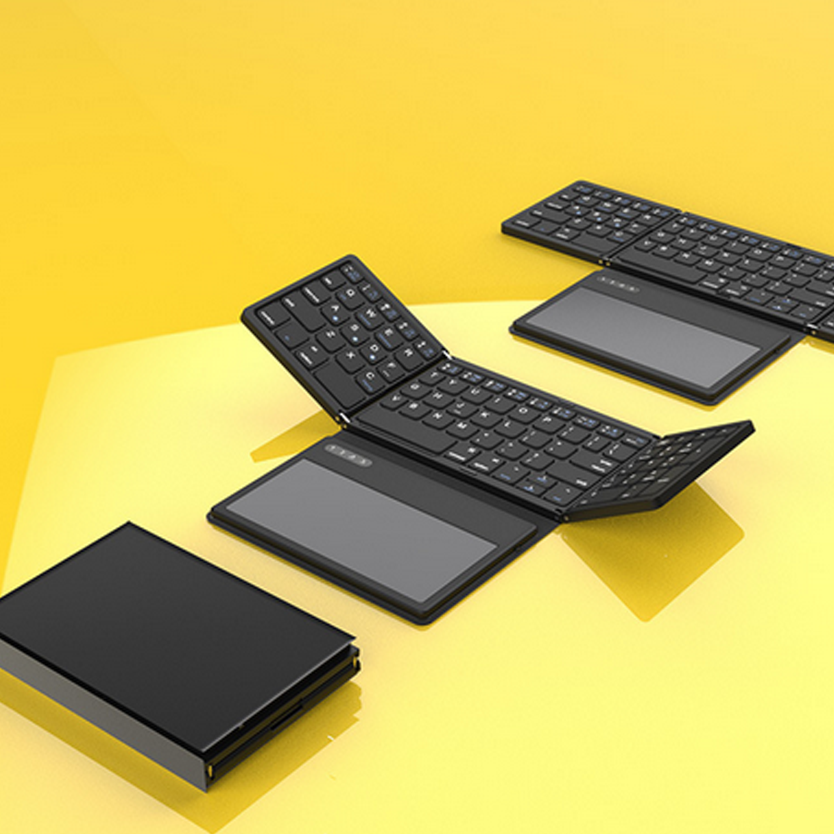 Faltbare schwarze Tastaturen auf gelbem Hintergrund mit grauem Touchpad.