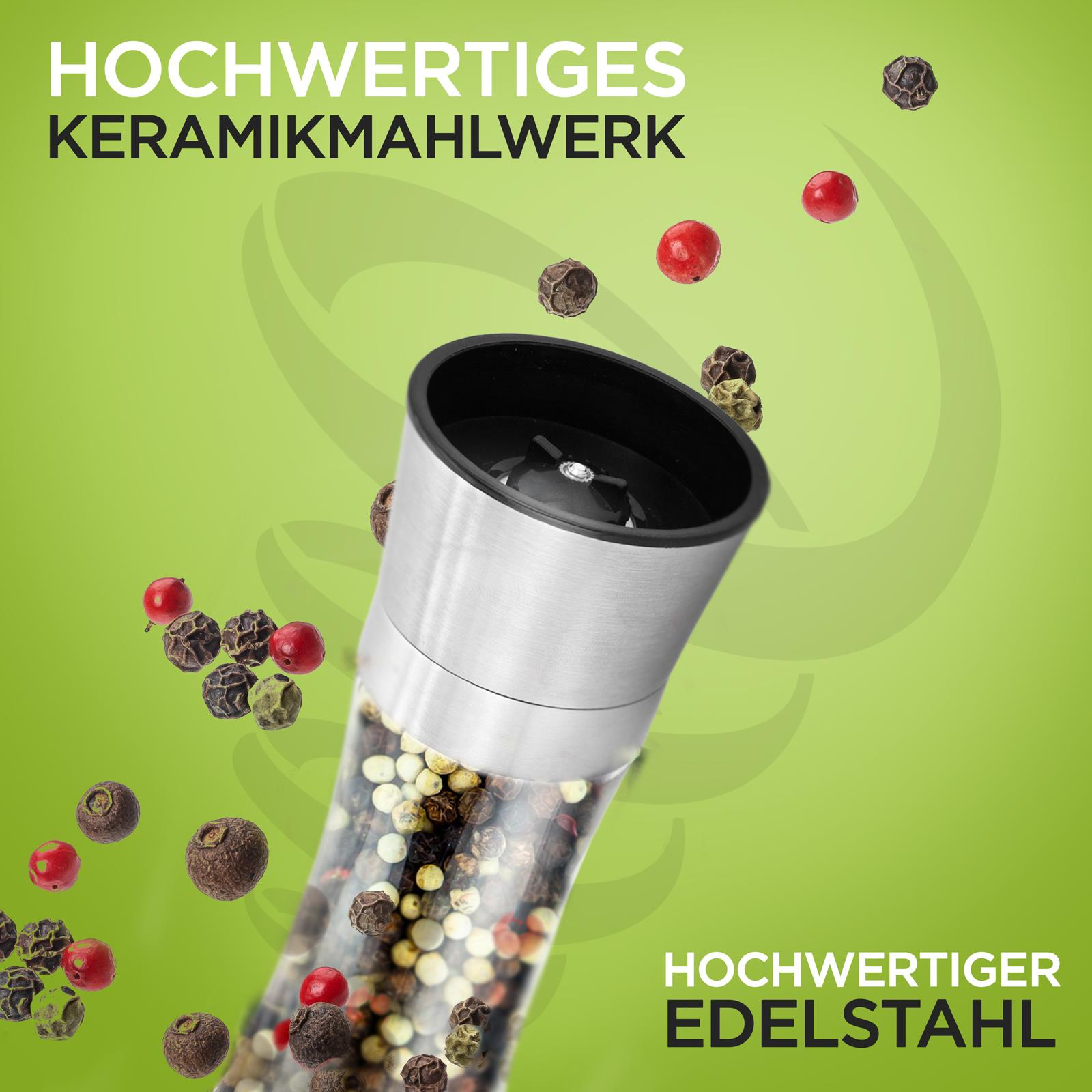Pfeffermühle aus Edelstahl mit Pfefferkörnern und roten Beeren.