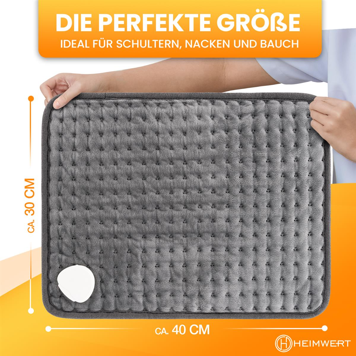 Ein graues Heizkissen mit Abmessungen und einer Hand, die es hält.