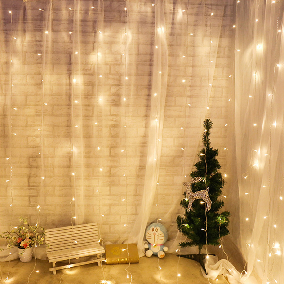Ein dekoriertes Zimmer mit Lichterketten, einem kleinen Weihnachtsbaum, einer Bank und einem Stofftier.