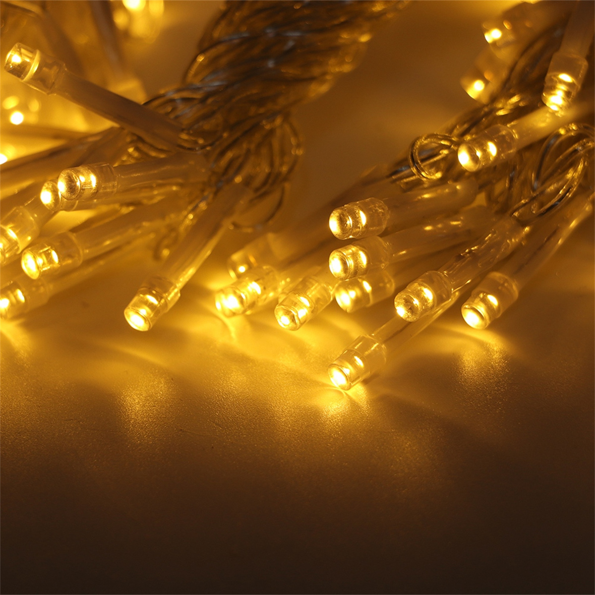 Nahaufnahme einer Lichterkette mit gelben Lichtern. Die Lichter sind an und leuchten hell.