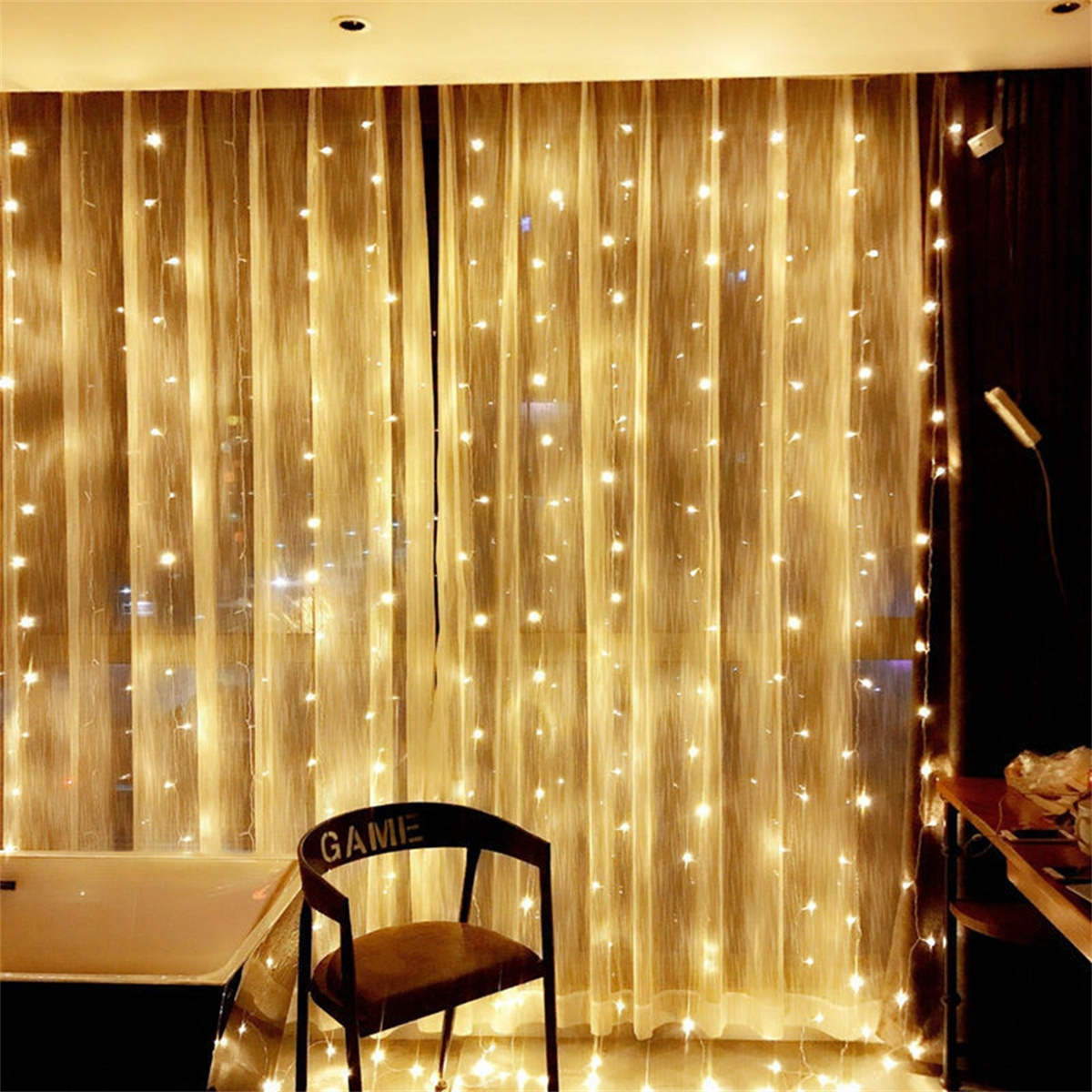 Vorhang mit vielen Lichtern. Ein Stuhl und ein Tisch sind in der Szene. Der Hintergrund ist ein Fenster und eine Wand.