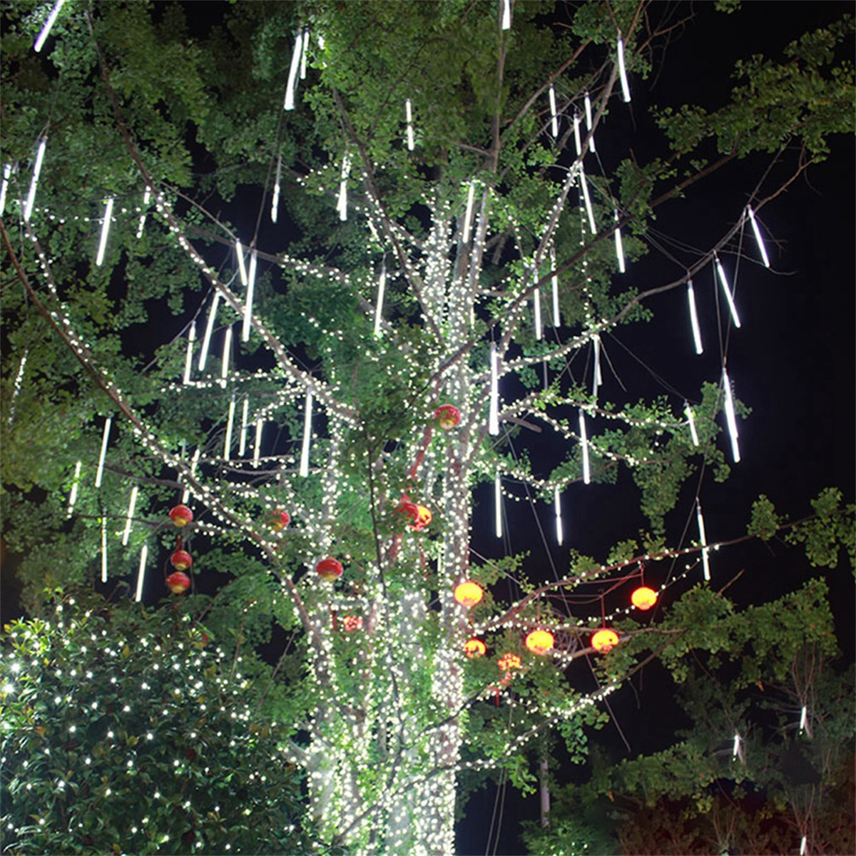 Baum mit Lichterketten und roten dekorativen Kugeln.