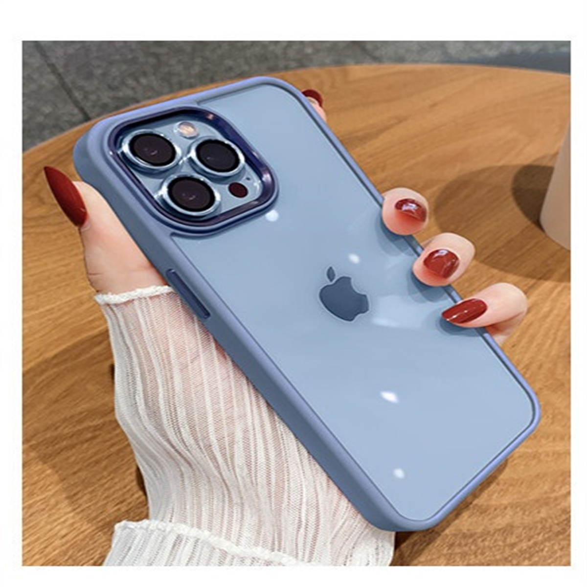 Die Hand einer Person, die eine blaue Handyhülle mit durchsichtigem Rücken und silbernen Kameraringen hält.