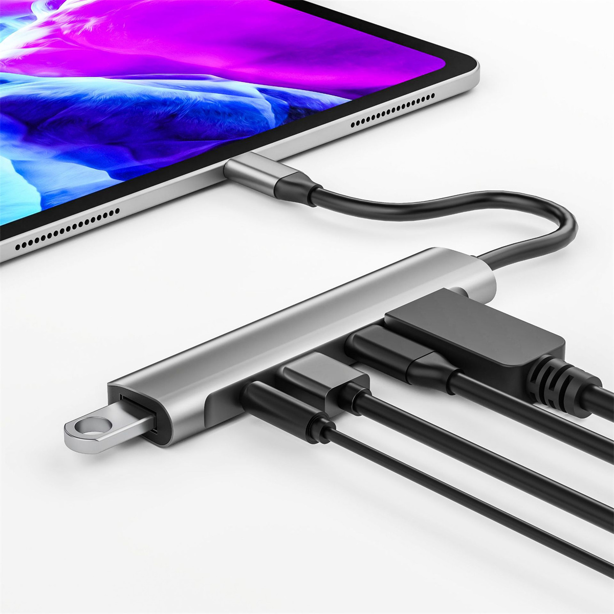 Ein silberner Hub, der mit einem Tablet verbunden ist, an dem mehrere schwarze Kabel befestigt sind.
