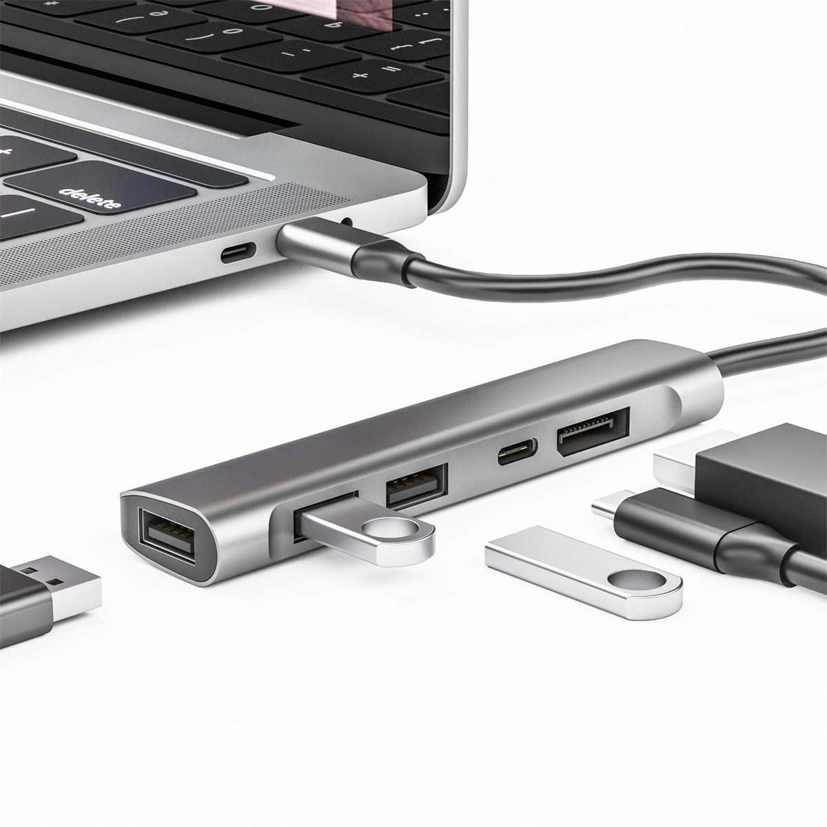 Silberner USB-Hub mit mehreren Anschlüssen, verbunden mit einem Laptop mit anderen Geräten.