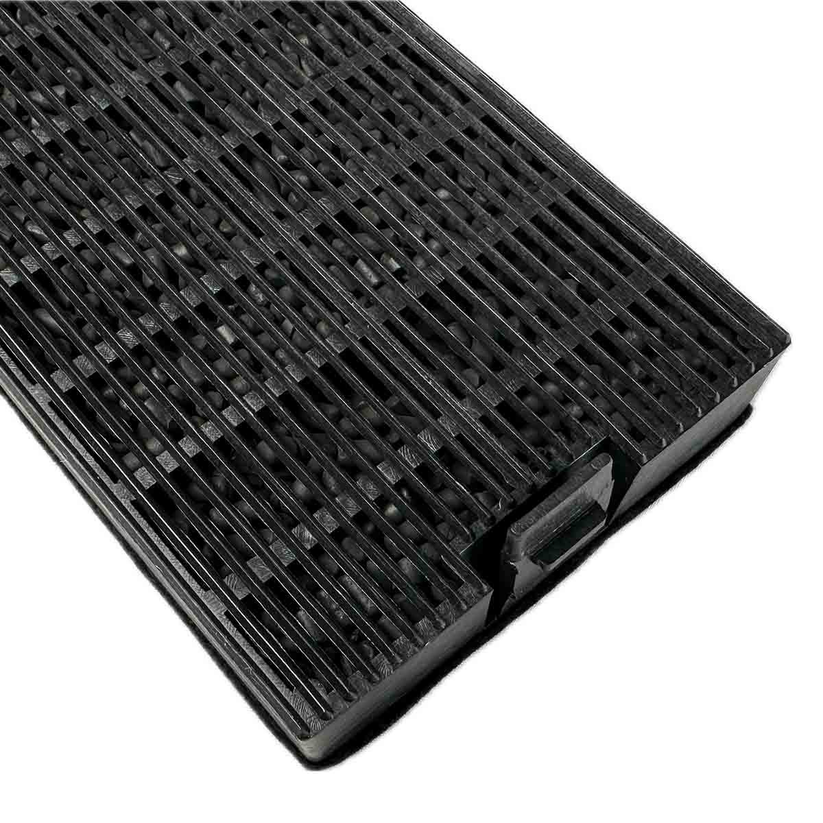 Schwarze, strukturierte Gummimatte mit parallelen Linien und kleinen Lücken auf weißem Hintergrund.