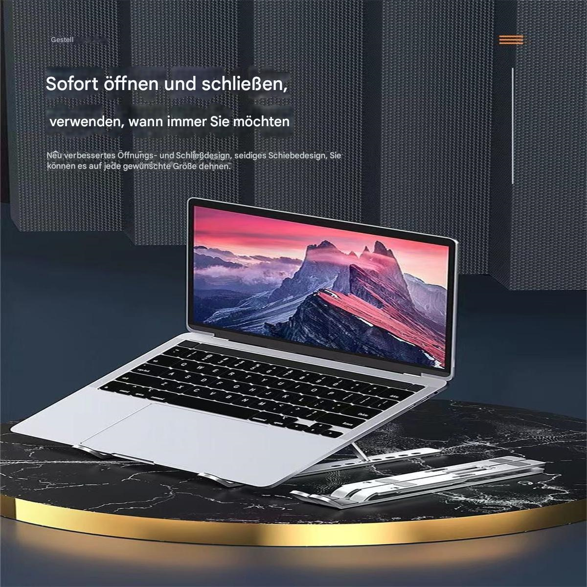 Ein Laptop auf einem Ständer mit einem Berg-Bild auf dem Bildschirm. Dunkle Marmoroberfläche.