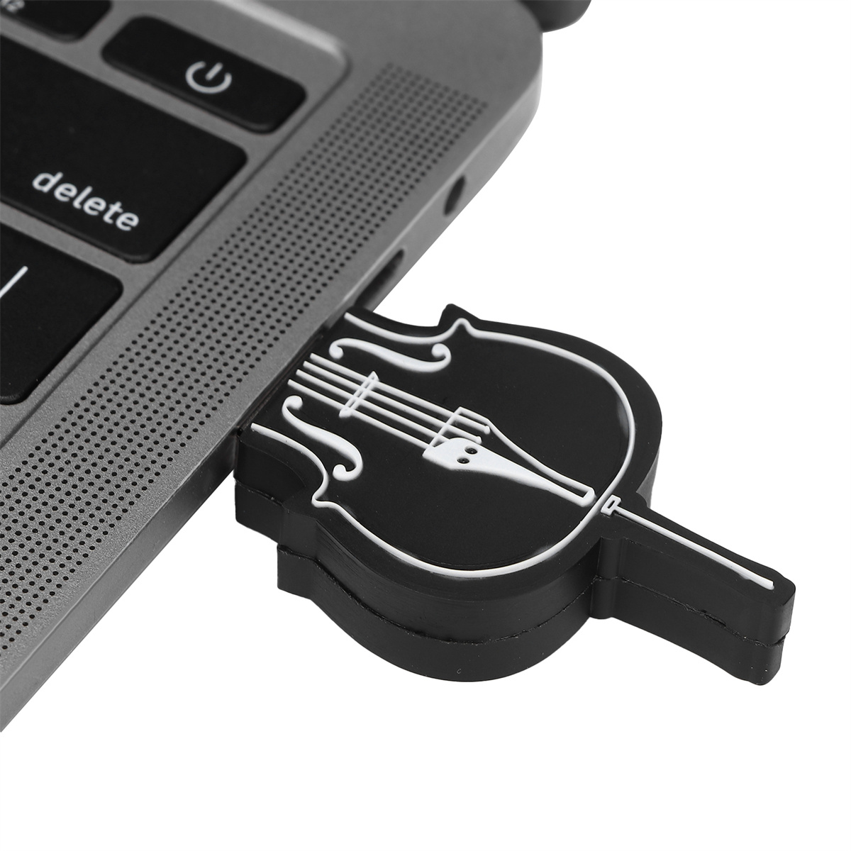 Ein schwarzer USB-Stick in Form eines Cellos ist in einen grauen USB-Anschluss eines Laptops gesteckt.