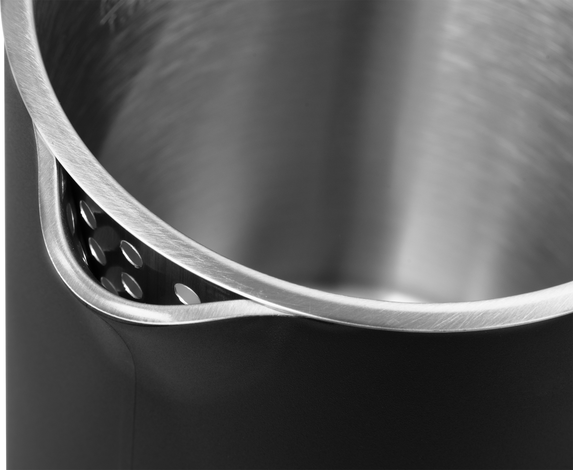 Zbliżenie wnętrza czarnego i srebrnego czajnika. Widoczny perforowany panel boczny.