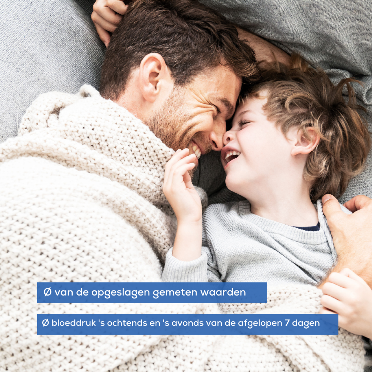 Vater und Kind lächeln unter einer Decke. Blauer Text unten.