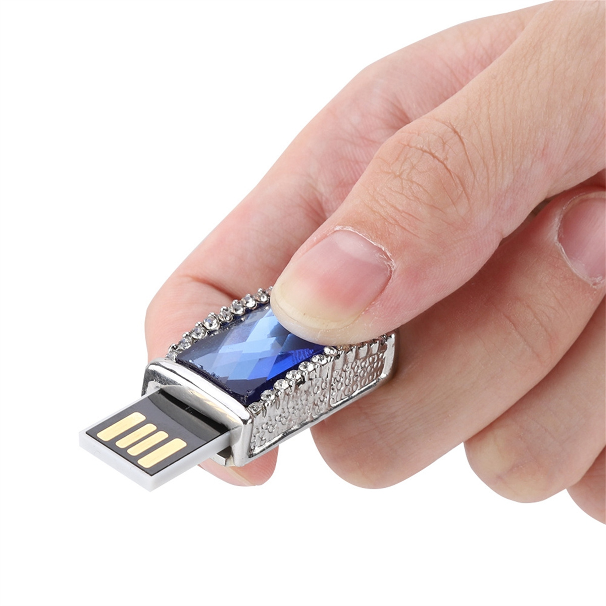 Hand hält USB-Stick mit blauem Edelstein und silbernen Akzenten. USB-Anschluss sichtbar.