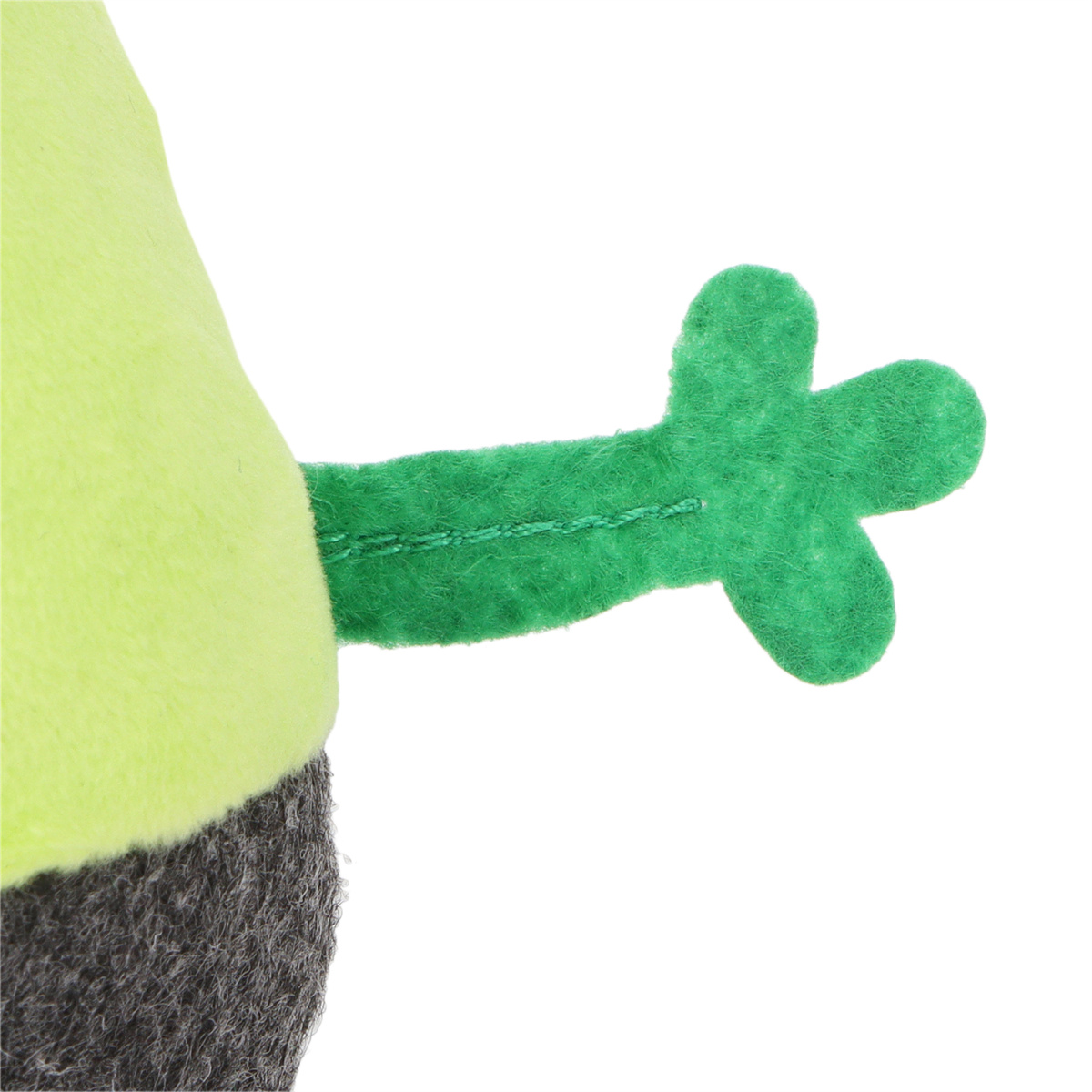 Nahaufnahme eines grünen Stoffarms mit einer dreiblättrigen Hand, die an einer grünen Stoffpuppe befestigt ist.