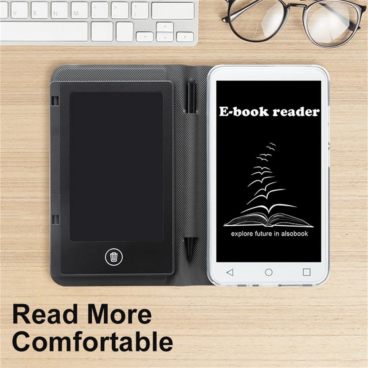 Ein E-Book-Reader und ein schwarzes E-Ink-Tablet auf einem Holztisch. Brille und Tastatur liegen auf dem Tisch.