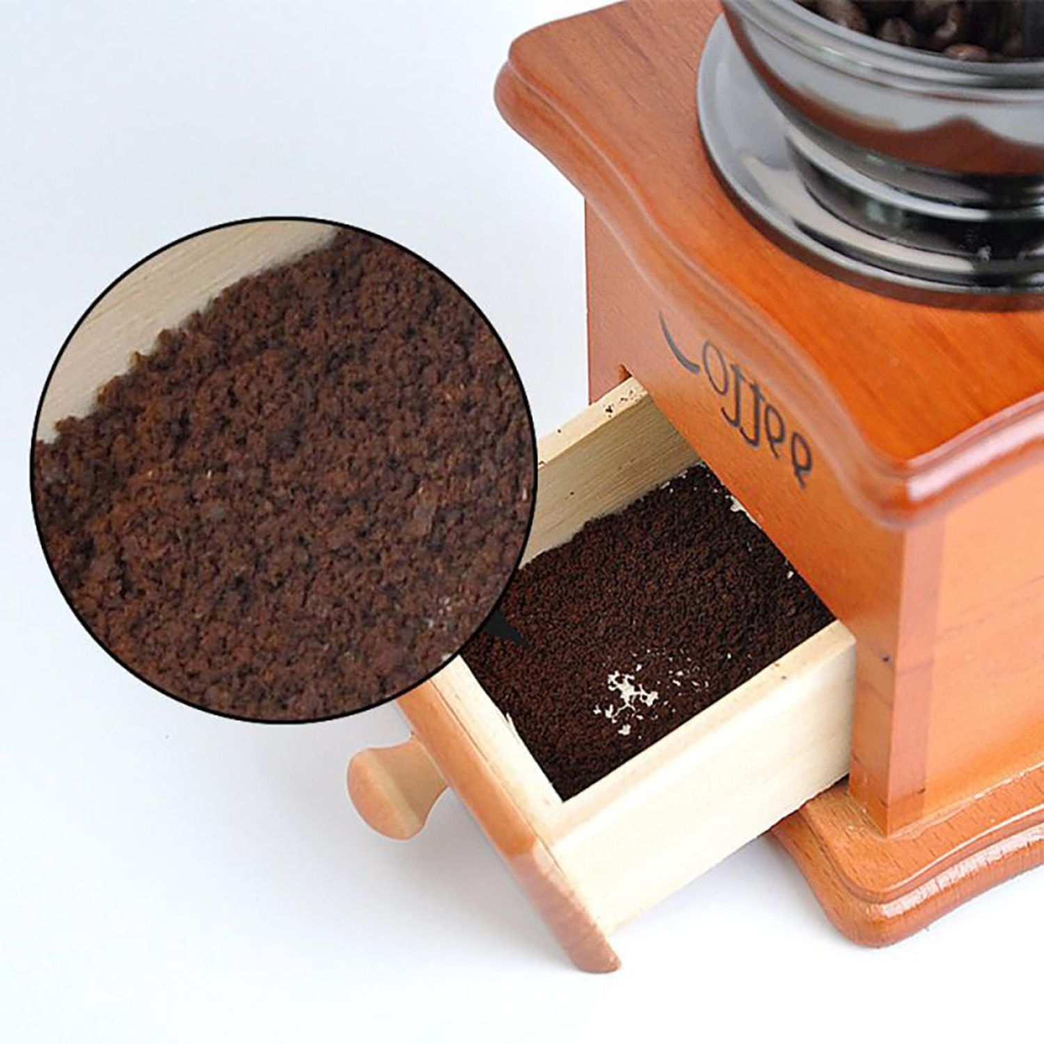 Nahaufnahme einer hölzernen Kaffeemühle mit gemahlenem Kaffee in der Schublade und vergrößerter Ansicht.