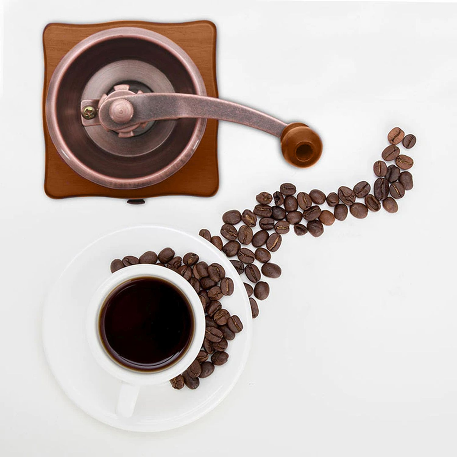 Draufsicht auf eine Kaffeemühle, eine Tasse Kaffee und Kaffeebohnen auf weißer Oberfläche.