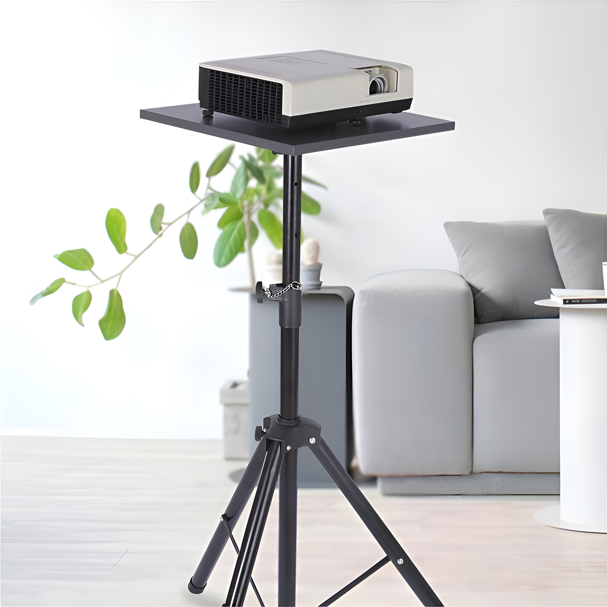 Weißer Projektor auf einem schwarzen Ständer mit Stativfuß, in einem Wohnzimmer aufgestellt.