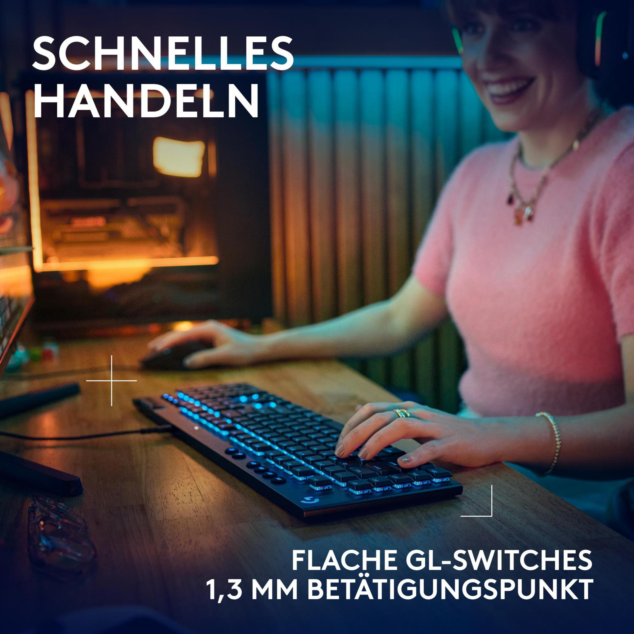 Eine Frau benutzt eine Gaming-Tastatur mit blauen Lichtern, lächelt, in einem Gaming-Setup.