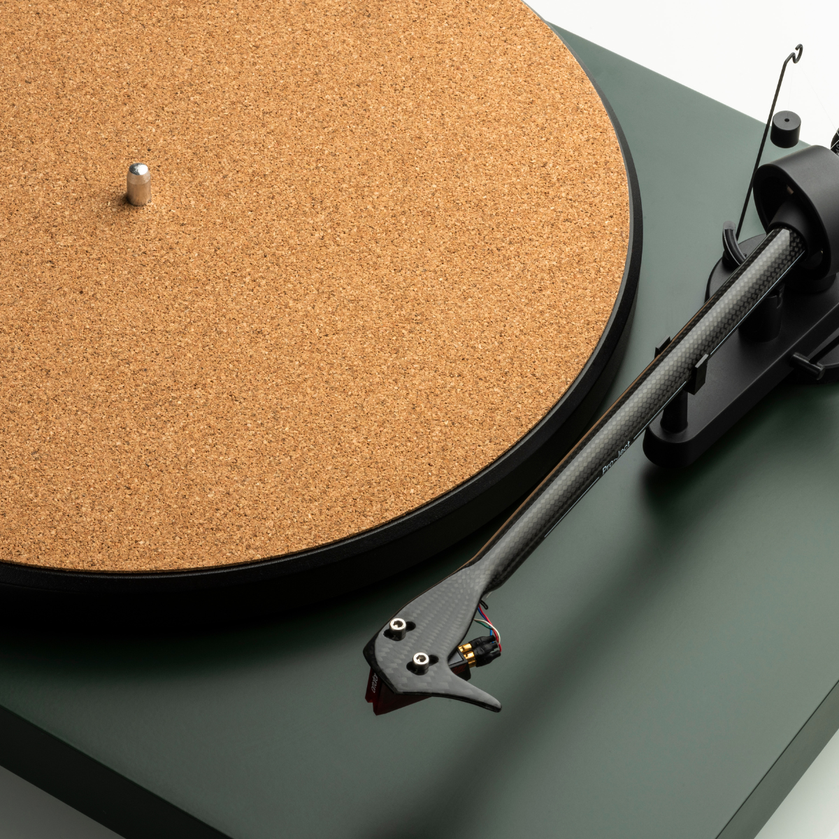Gramofon z ramieniem z włókna węglowego, matą korkową i zieloną podstawą.