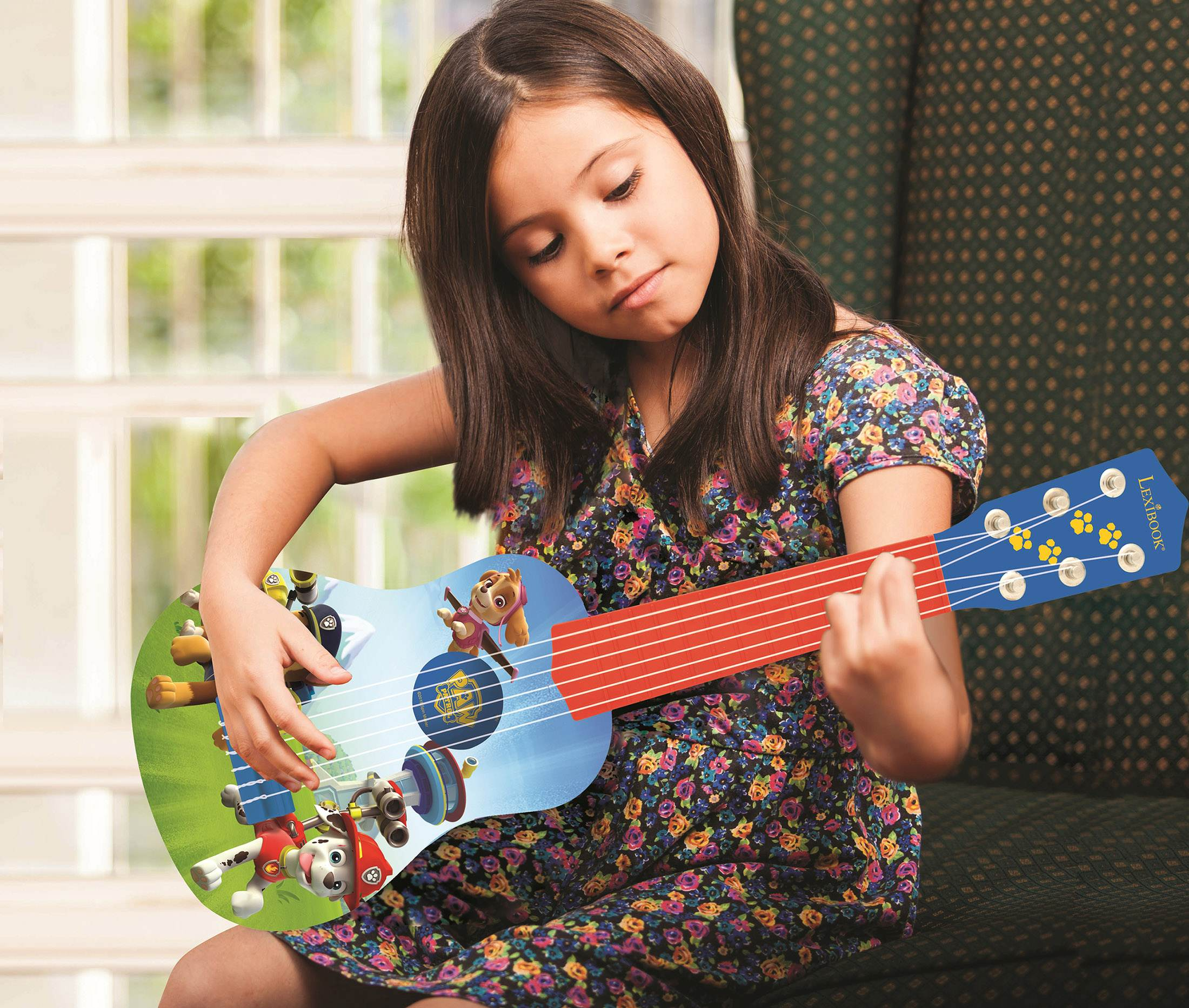 Dziewczyna gra na gitarze z postaciami z kreskówek, w kwiatowej sukience, w pokoju z oknem.