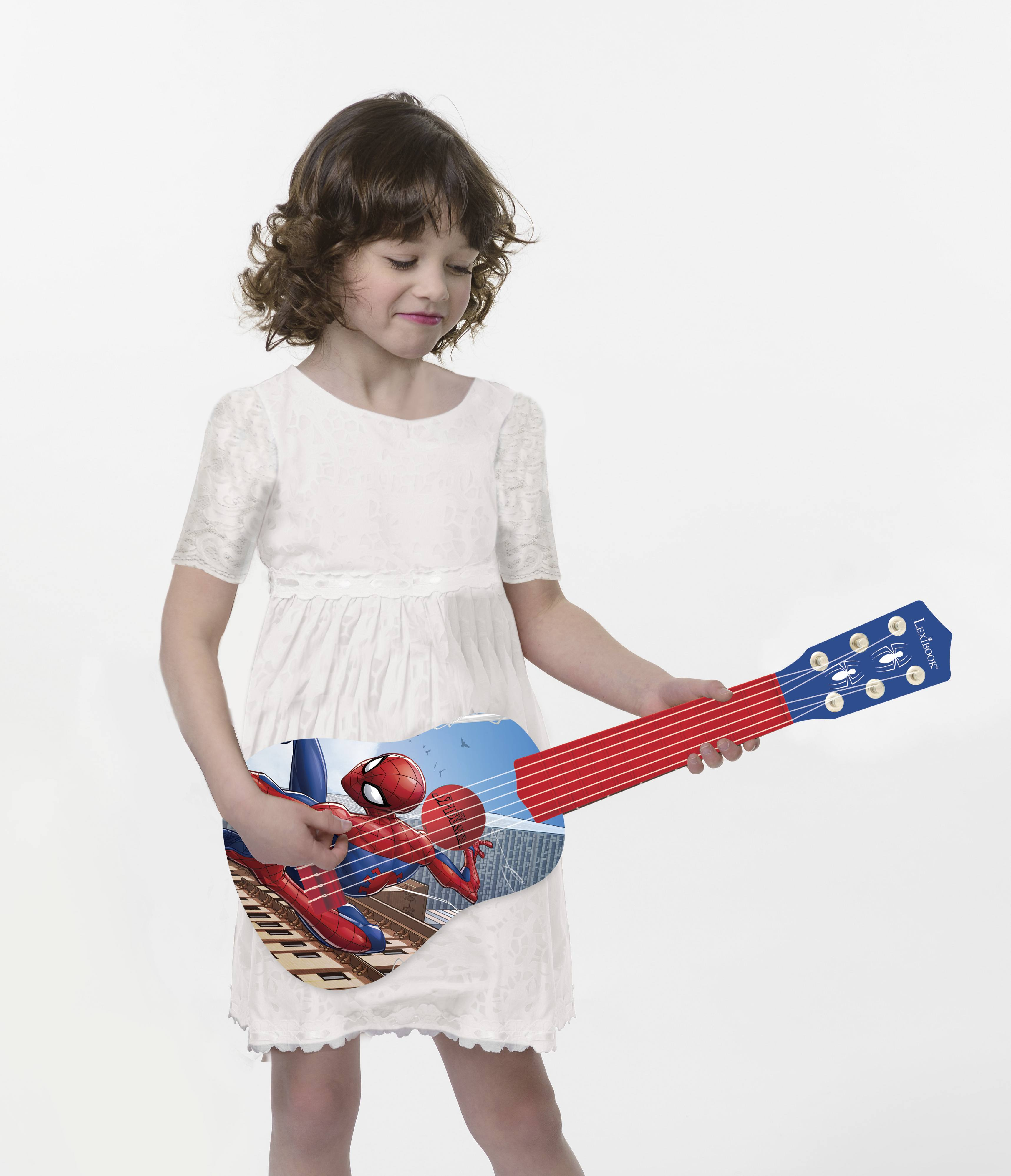 Una niña en un vestido blanco sosteniendo y fingiendo tocar una guitarra de juguete con temática de Spider-Man.