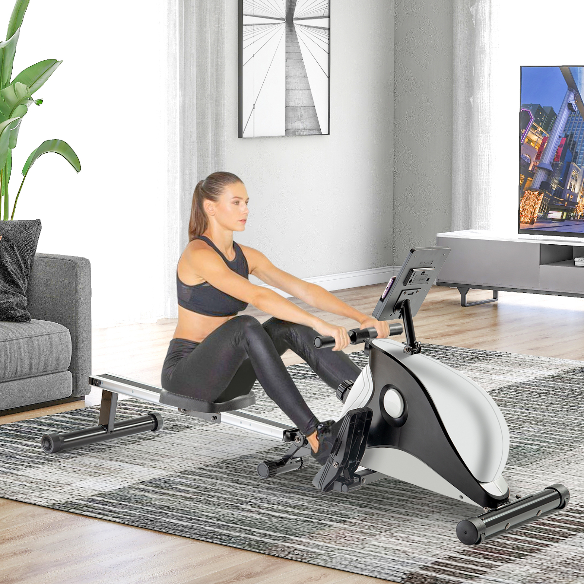 Frau rudert auf einem Gerät in einem Wohnzimmer. Im Hintergrund ein Fernseher und ein Sofa.