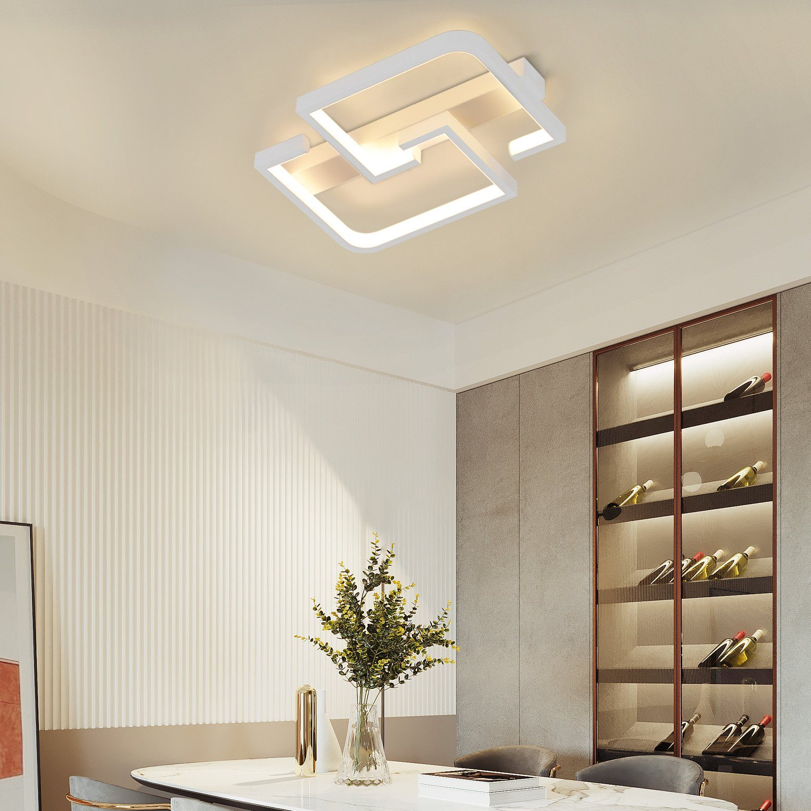 Luminaria de techo moderna. Tiene un diseño geométrico blanco. Está montada en un techo blanco.