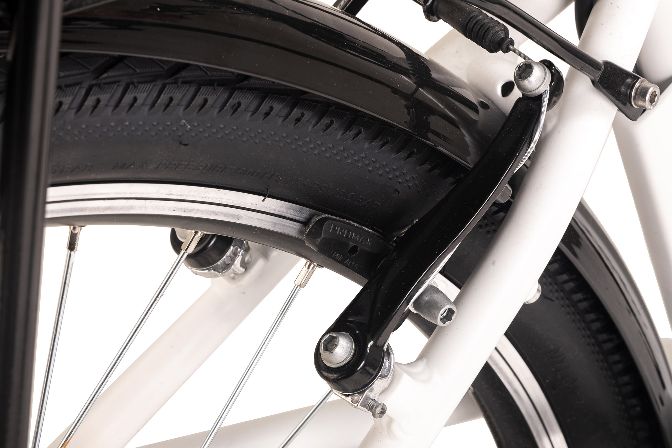 Nahaufnahme einer Fahrradbremse, mit sichtbaren Bremsbelägen und Reifen im Hintergrund.