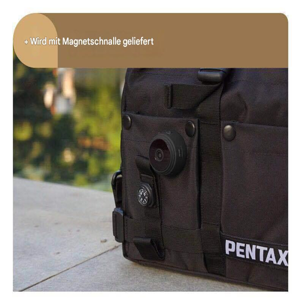 Eine kleine schwarze Kamera, die an einer schwarzen Tasche befestigt ist, mit einem Kompass daneben.
