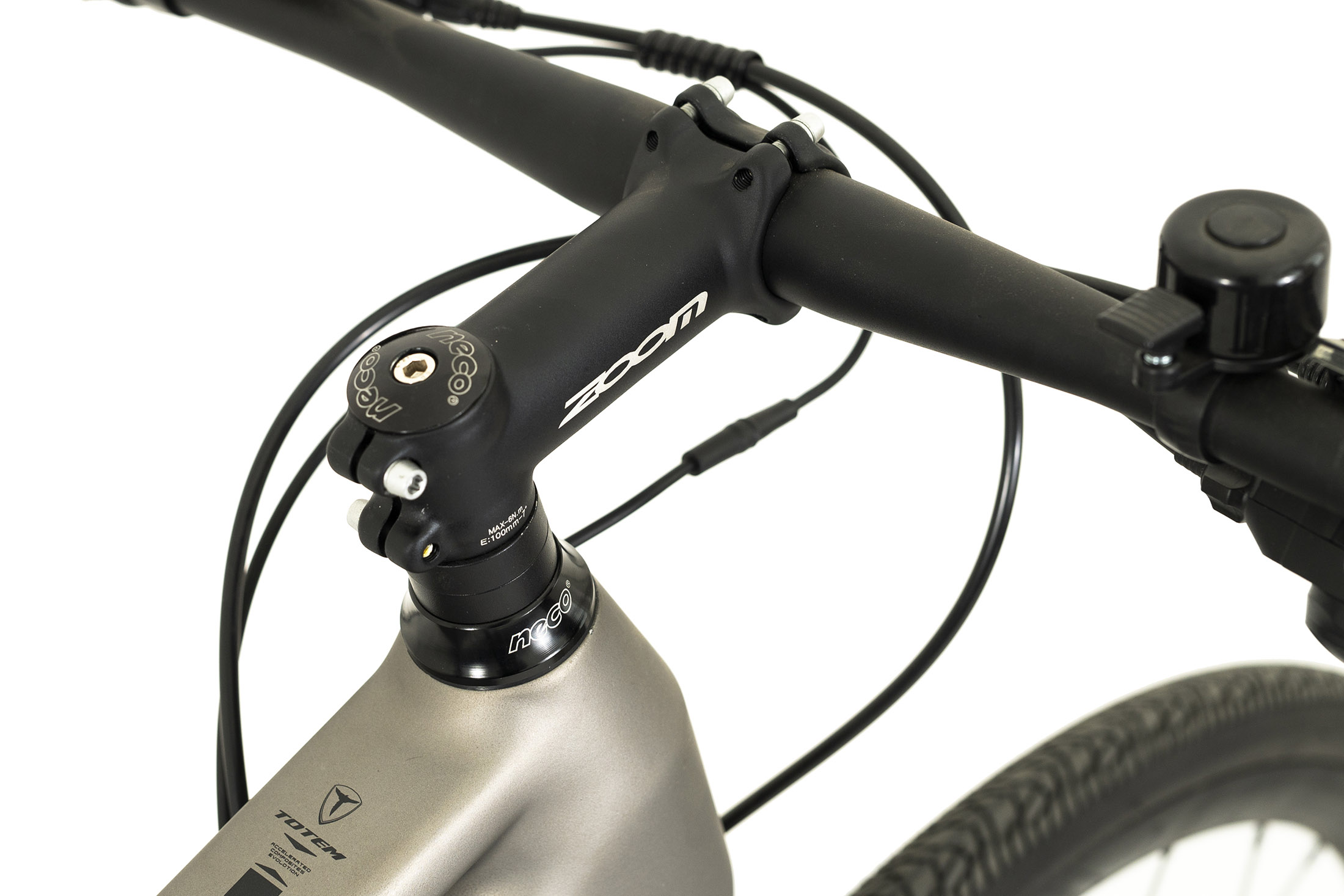 Fahrradlenker mit schwarzem Vorbau, Zoom-Logo und Klingel. Das Fahrrad ist grau und hat einen schwarzen Reifen.