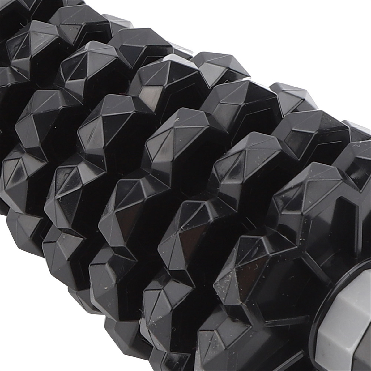 Schwarze Faszienrolle mit strukturierter Oberfläche. Die Rolle hat eine Reihe von Diamantformen.
