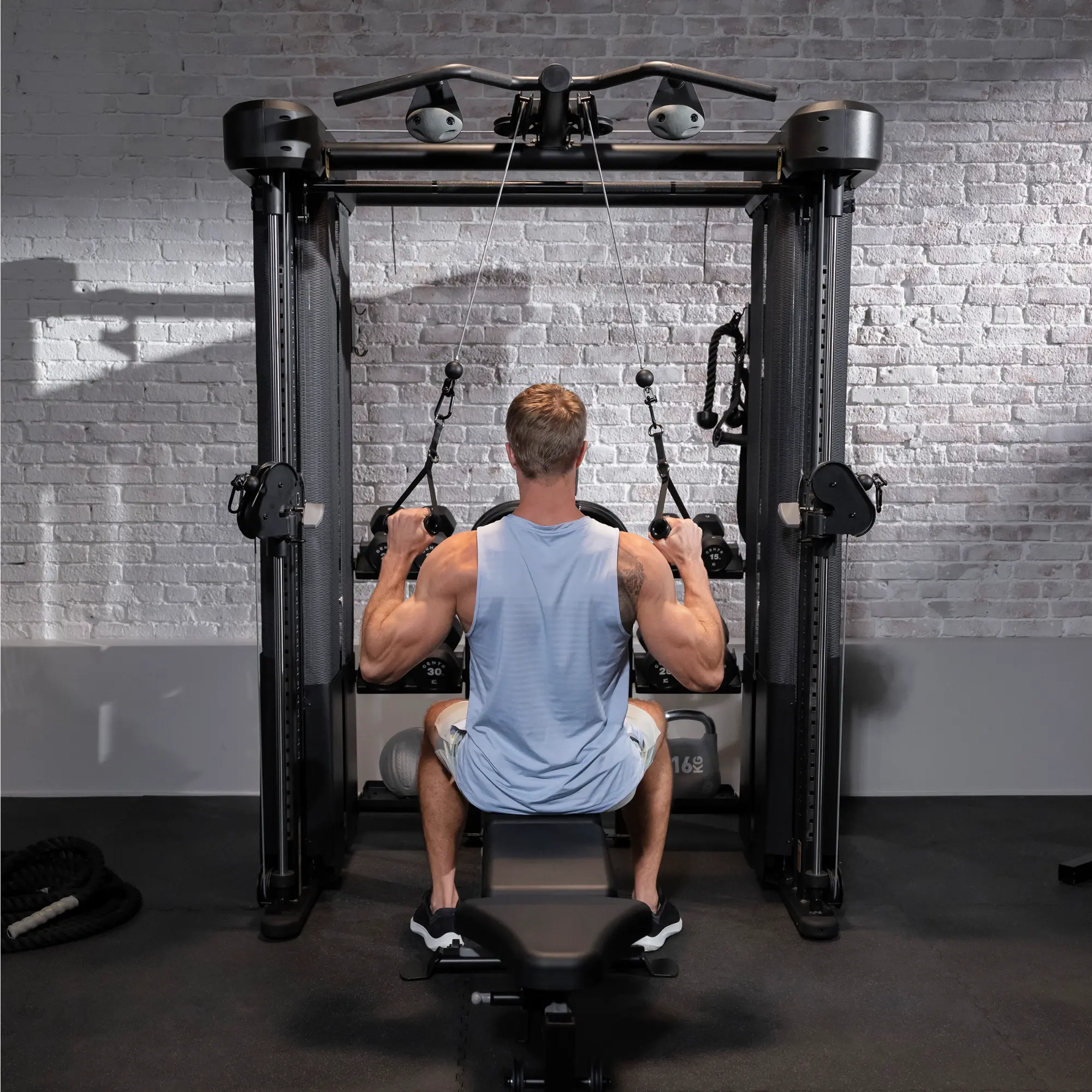 Ein Mann benutzt eine Gewichtsmaschine, von hinten gesehen, in einem Fitnessstudio.