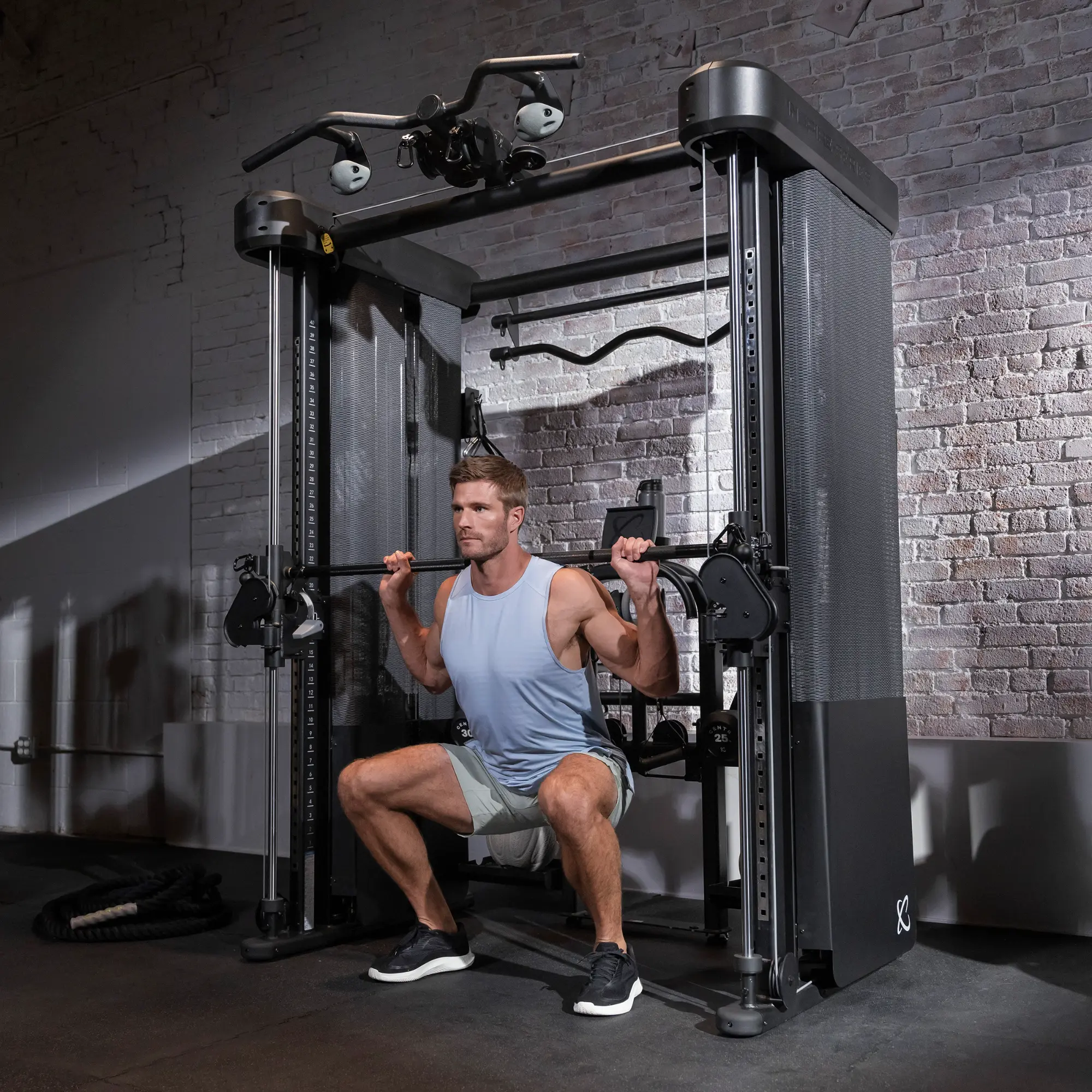 Mann im Fitnessstudio, der ein Krafttrainingsgerät benutzt. Gewichte sind am Gerät befestigt.