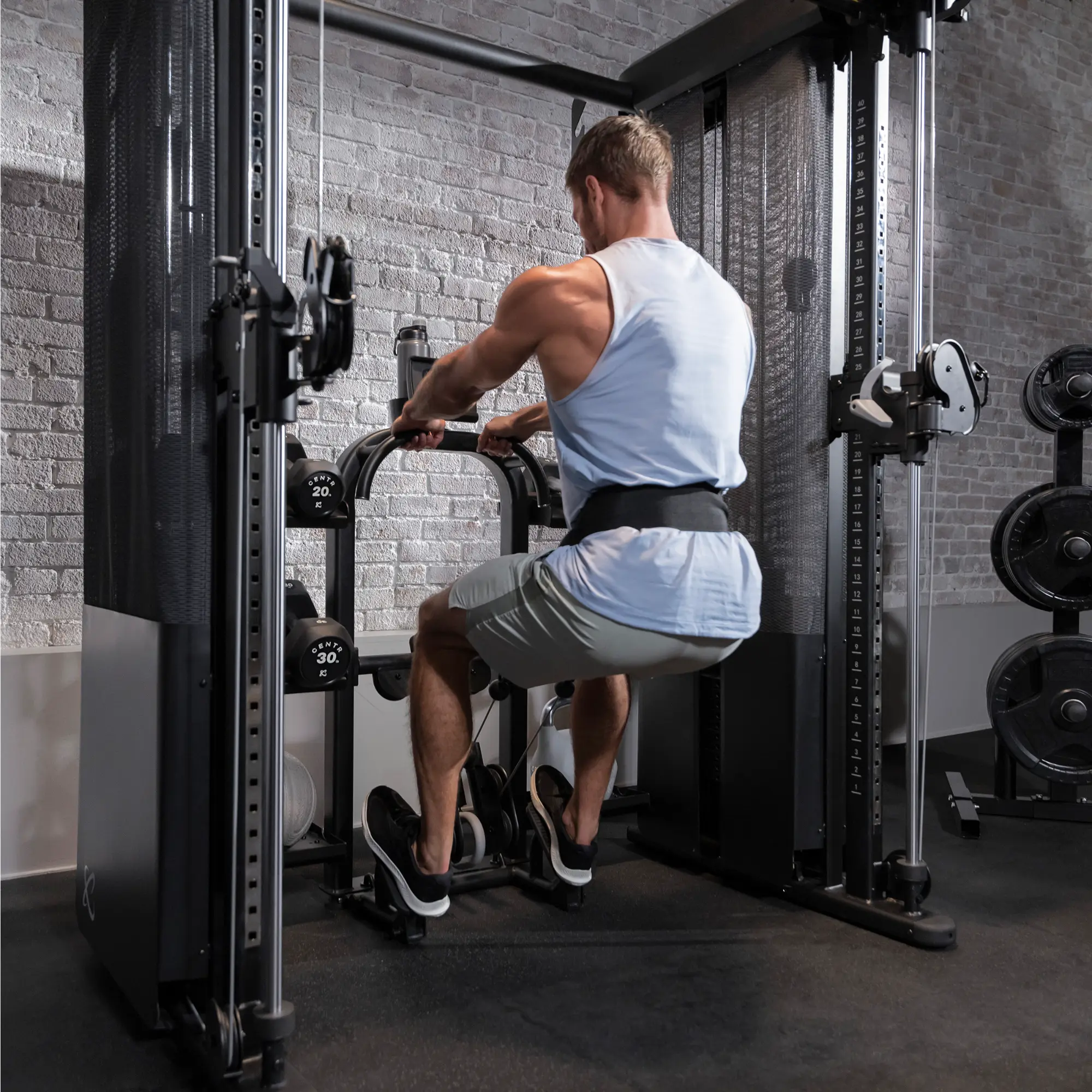 Ein Mann benutzt eine Rudermaschine im Sitzen in einem Fitnessstudio und hebt Gewichte.