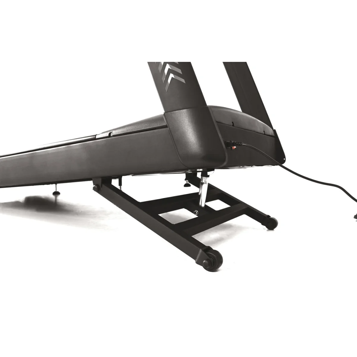 Low angle view of a black treadmill with an arrow design on the top.  Shows the legs and the power cord.