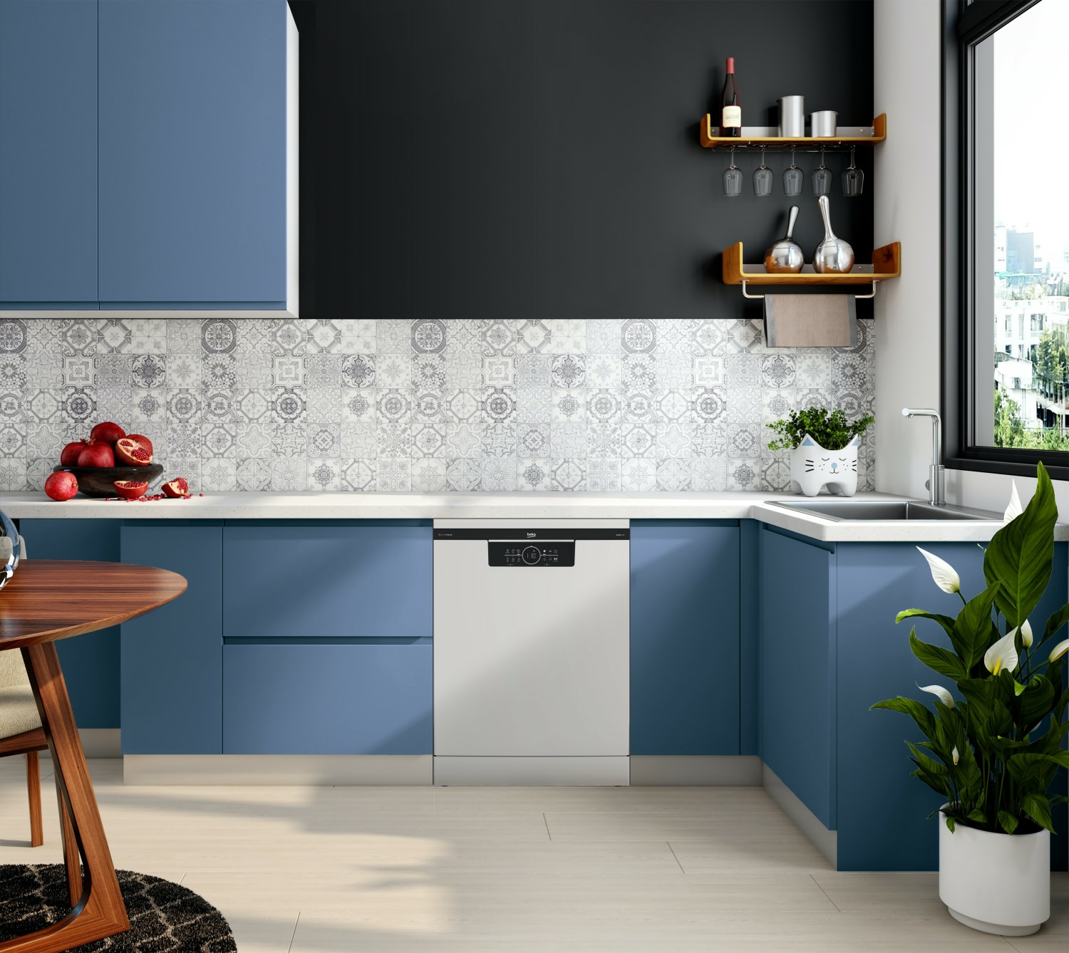 Kuchnia z niebieskimi szafkami, białą zmywarką i czarną ścianą akcentującą. Drewniany stół i rośliny.