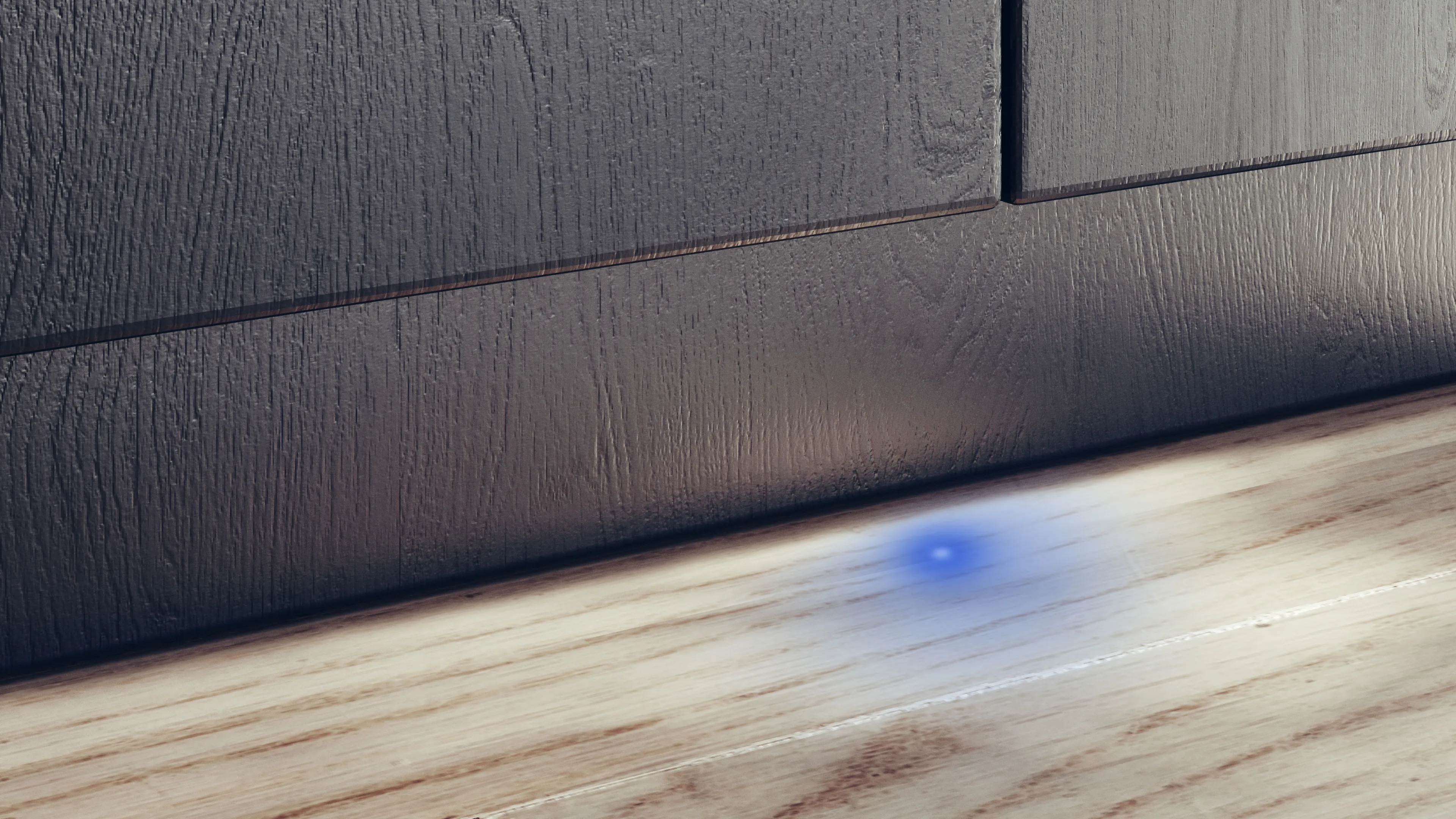 Houten panelen op een muur, met een kleine blauwe lichtvlek op de houten vloer.