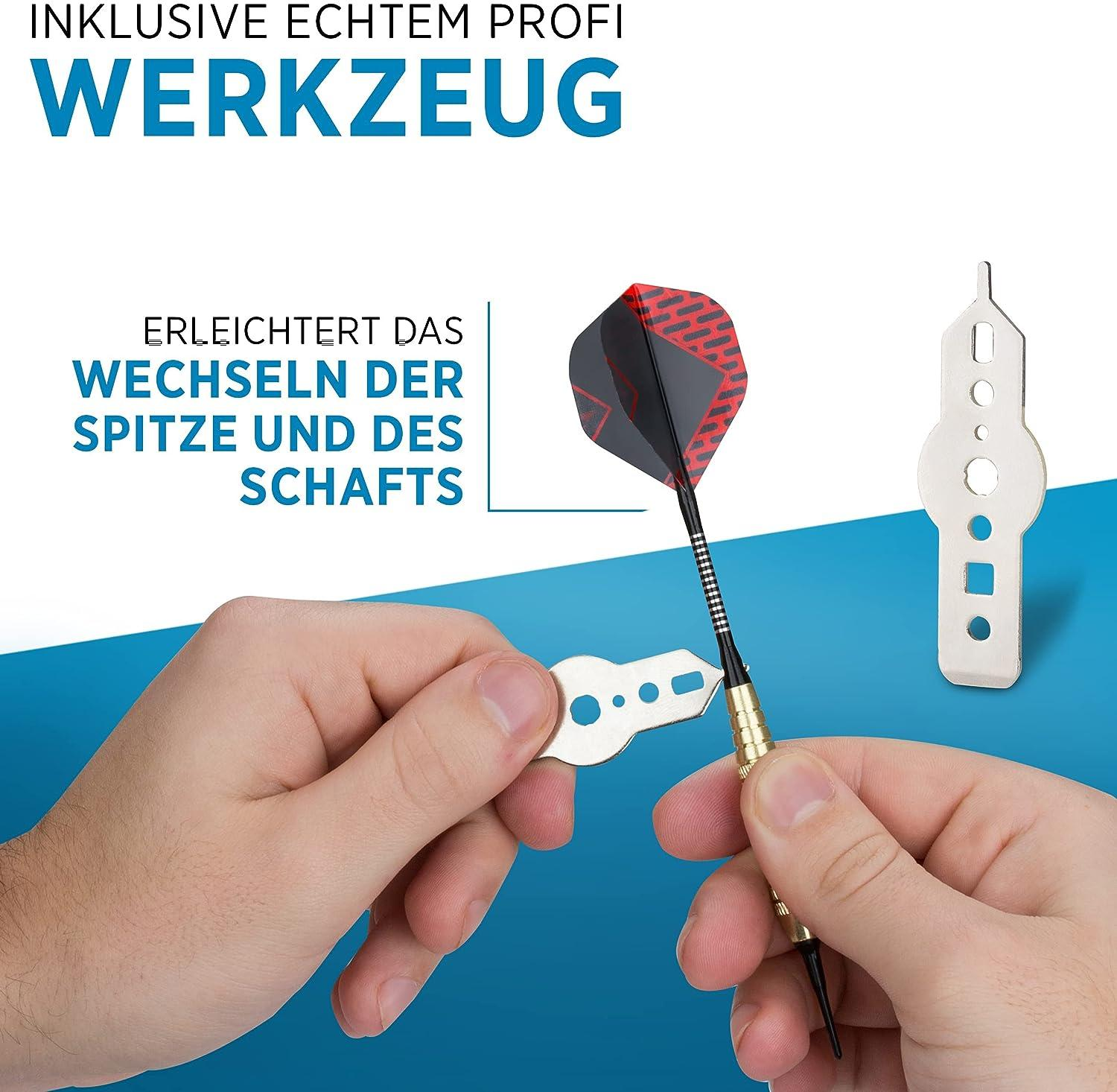 Hände wechseln mit einem Werkzeug eine Dartspitze; Dart und Werkzeug sind sichtbar.