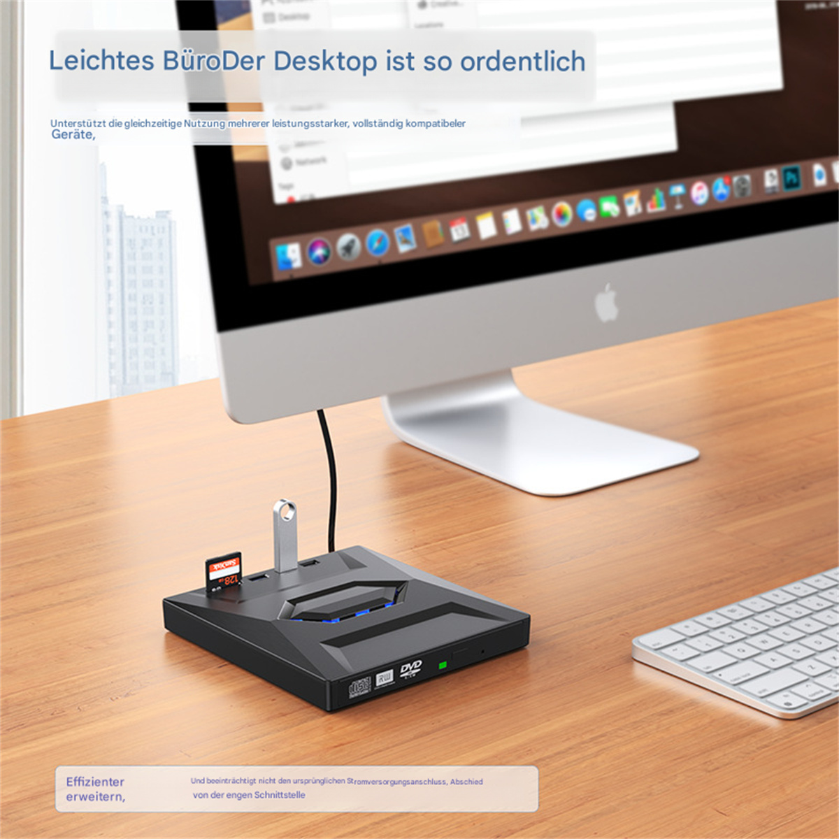Desktop-Setup mit Bildschirm, Tastatur und einem schwarzen Gerät mit Karten.