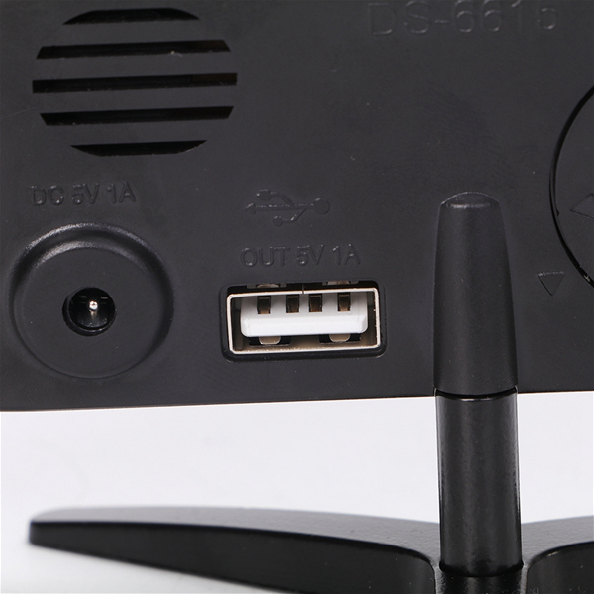 Das Bild zeigt die Rückseite einer schwarzen Digitaluhr mit Eingangs-/Ausgangsanschlüssen. USB-Anschluss ist deutlich sichtbar.